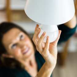 woman changing light bulb