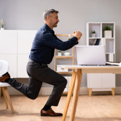 man stretching at desk