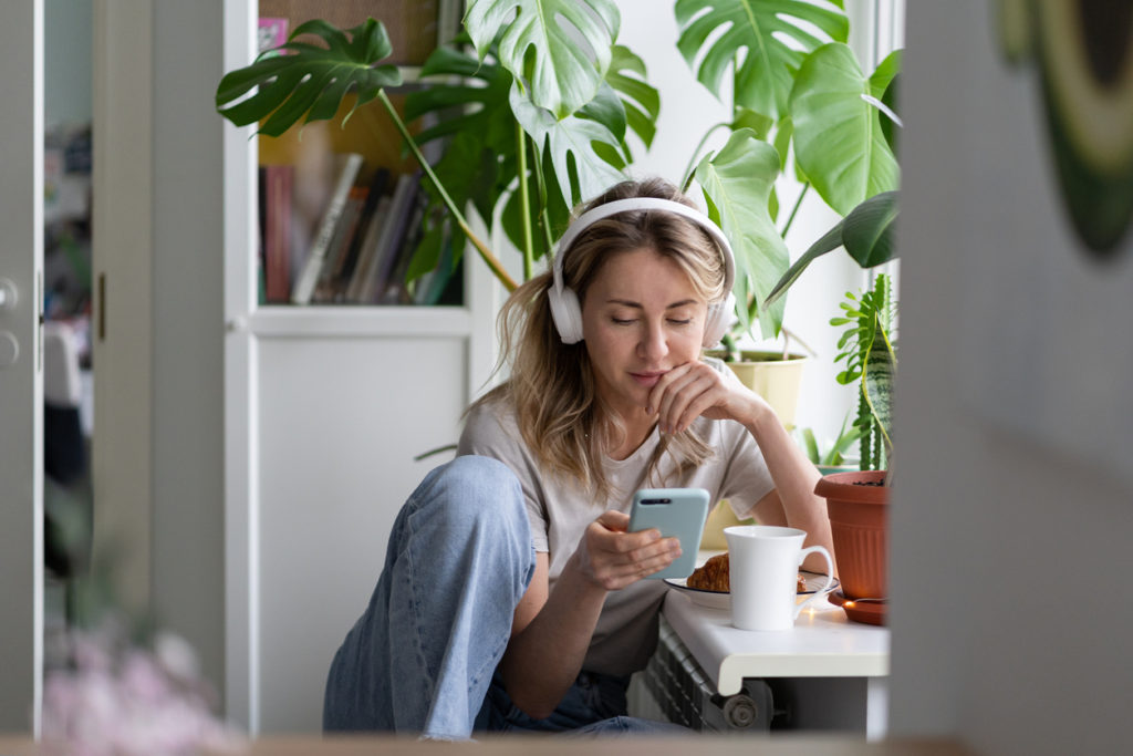 Women using phone, listening to podcast